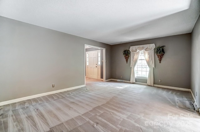 spare room with light hardwood / wood-style floors and a textured ceiling