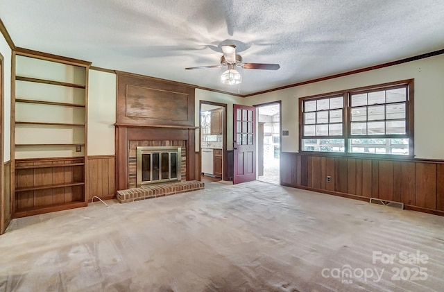 unfurnished living room featuring crown molding, a fireplace, light carpet, and a textured ceiling