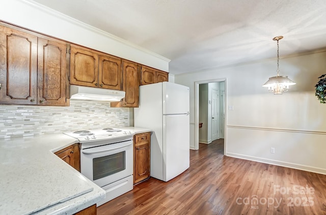 kitchen featuring crown molding, wood-type flooring, decorative light fixtures, white appliances, and backsplash