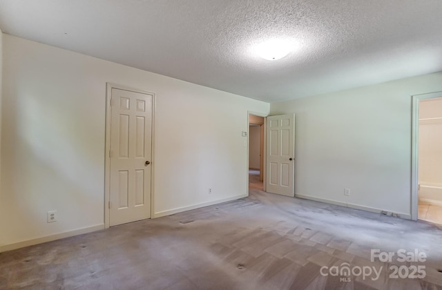 empty room featuring a textured ceiling and carpet flooring