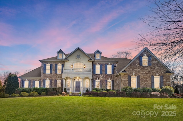 colonial-style house with a balcony and a yard