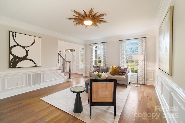 living room with wood-type flooring and ornamental molding