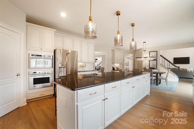 kitchen with white cabinetry, decorative light fixtures, and a kitchen island