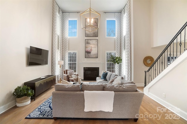 living room featuring hardwood / wood-style flooring and a towering ceiling