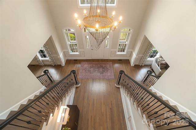 entrance foyer featuring a towering ceiling, a wealth of natural light, and dark hardwood / wood-style floors