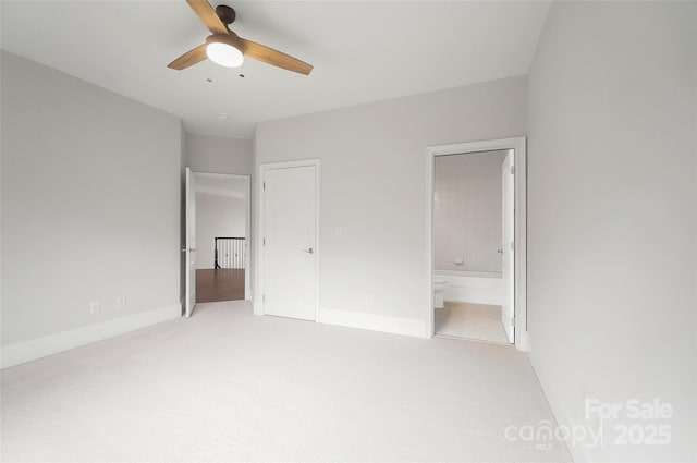 unfurnished bedroom with ensuite bath, light colored carpet, and ceiling fan