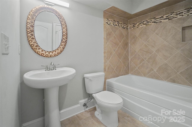 bathroom with tile patterned flooring, tiled shower / bath, and toilet