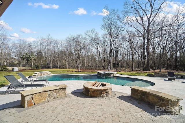 view of swimming pool with a patio, pool water feature, an in ground hot tub, and a fire pit