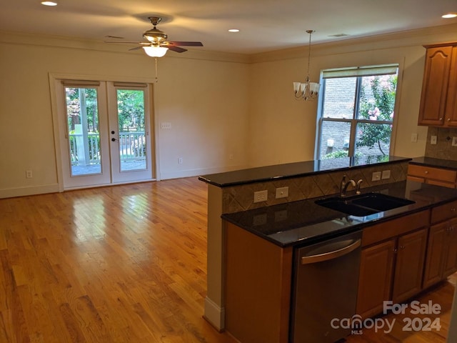 kitchen with sink, light wood-type flooring, ornamental molding, dishwasher, and backsplash