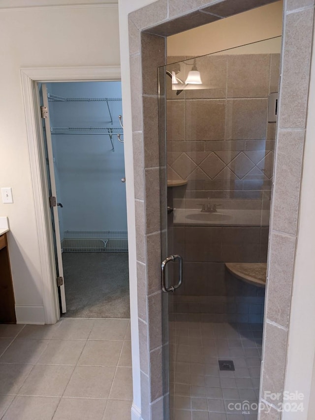 bathroom featuring tile patterned flooring, vanity, and a shower with shower door