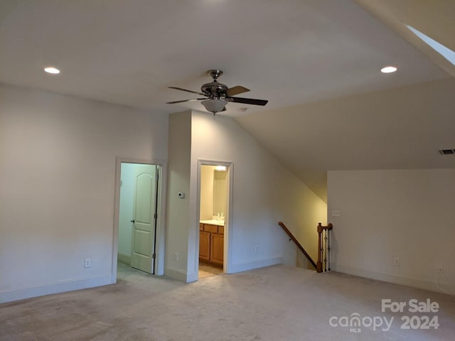 interior space featuring lofted ceiling, light colored carpet, and ceiling fan