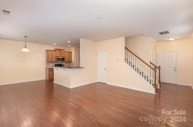 unfurnished living room with sink and hardwood / wood-style floors