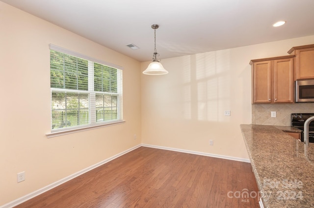 unfurnished dining area featuring hardwood / wood-style flooring and a wealth of natural light