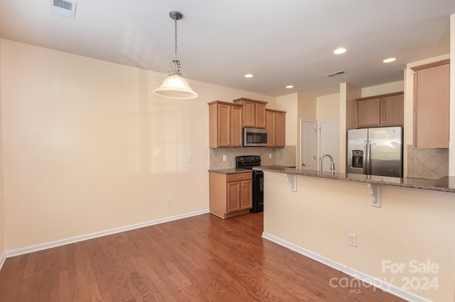 kitchen with hardwood / wood-style flooring, pendant lighting, tasteful backsplash, and stainless steel appliances