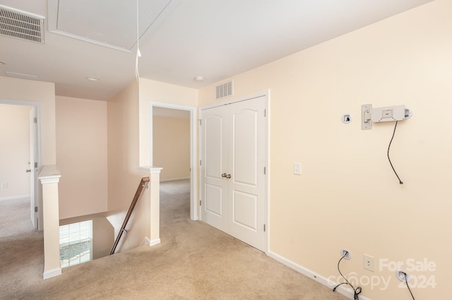 hall featuring light colored carpet