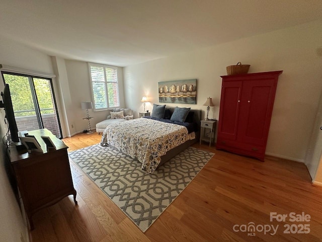 bedroom featuring access to exterior and light wood-type flooring