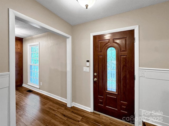 foyer with wood-type flooring and a textured ceiling