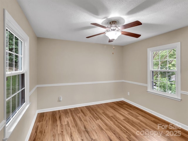 empty room with wood-type flooring and a textured ceiling