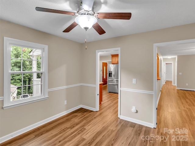 spare room featuring ceiling fan and light wood-type flooring