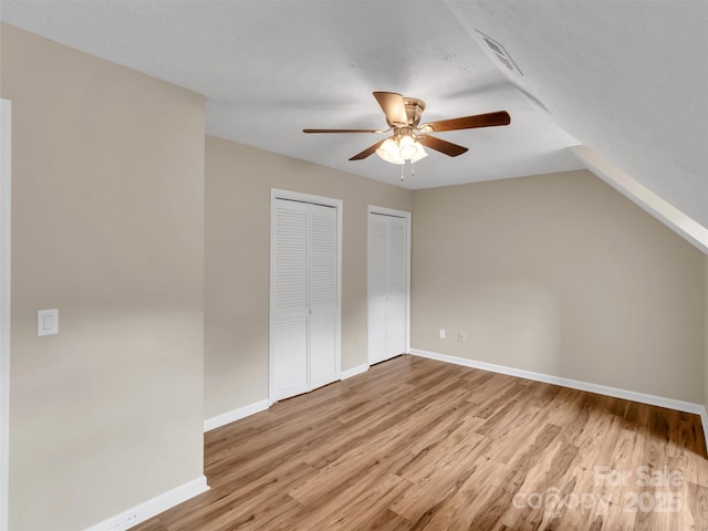 interior space featuring ceiling fan, vaulted ceiling, a textured ceiling, and light wood-type flooring