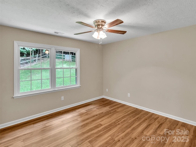 spare room with ceiling fan, a textured ceiling, and light hardwood / wood-style floors