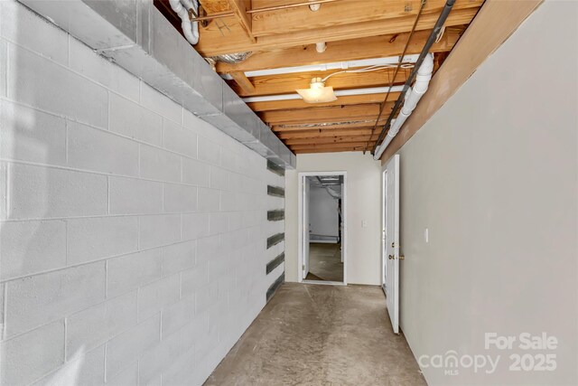 corridor with a baseboard radiator and concrete floors