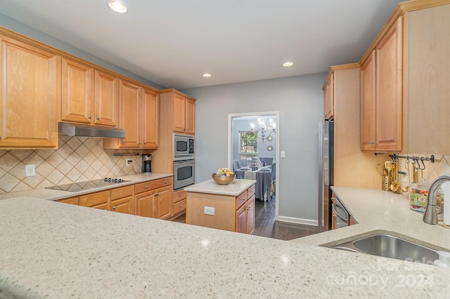 kitchen with stainless steel appliances, sink, a center island, dark hardwood / wood-style flooring, and tasteful backsplash