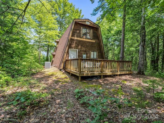 rear view of property featuring central AC and a wooden deck