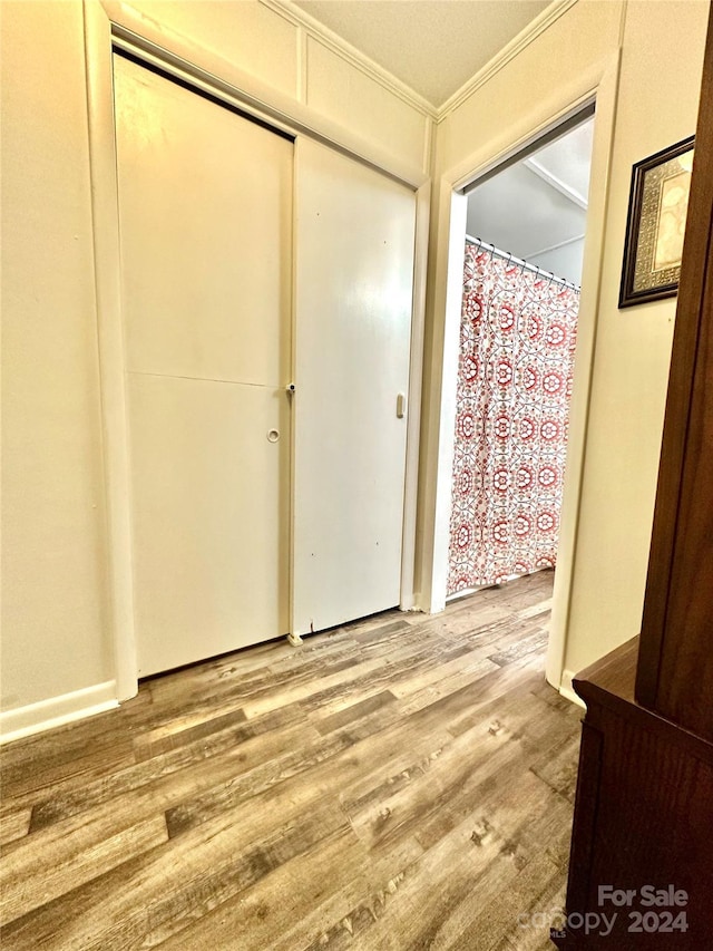 foyer entrance featuring wood-type flooring and ornamental molding