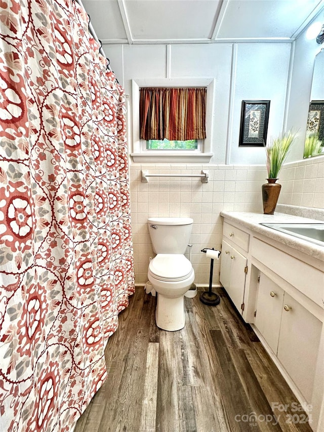 bathroom featuring hardwood / wood-style flooring, tile walls, toilet, and vanity