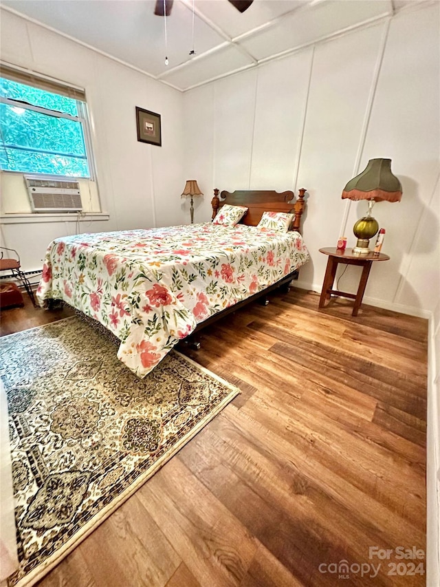 bedroom featuring ceiling fan, cooling unit, and hardwood / wood-style flooring