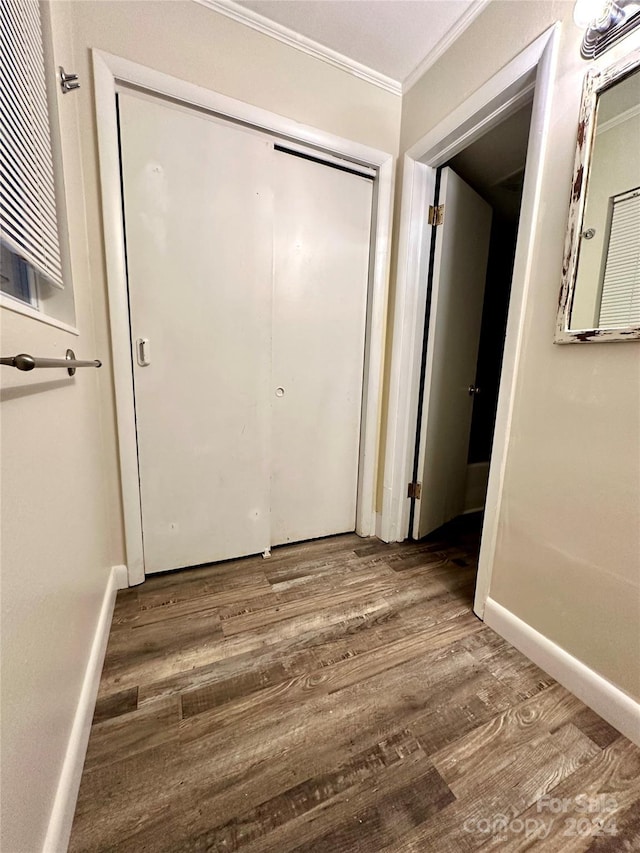 corridor with hardwood / wood-style floors and ornamental molding