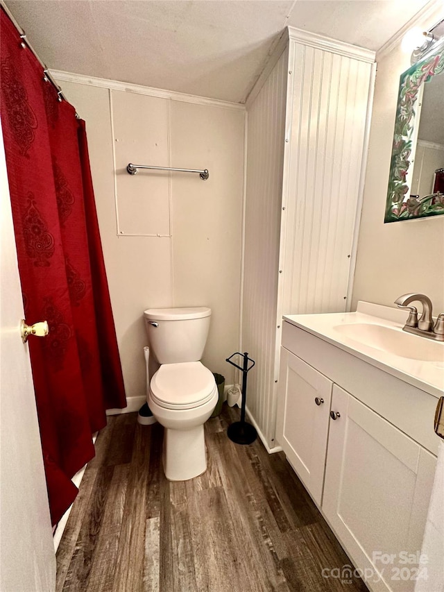 bathroom with toilet, a textured ceiling, ornamental molding, and hardwood / wood-style flooring