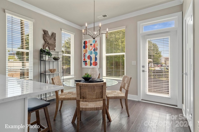 dining area with a wealth of natural light, dark hardwood / wood-style floors, ornamental molding, and an inviting chandelier