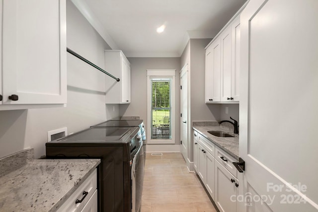 kitchen with sink, white cabinets, and light stone counters