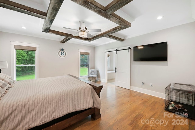 bedroom with light hardwood / wood-style flooring, multiple windows, a barn door, and ceiling fan