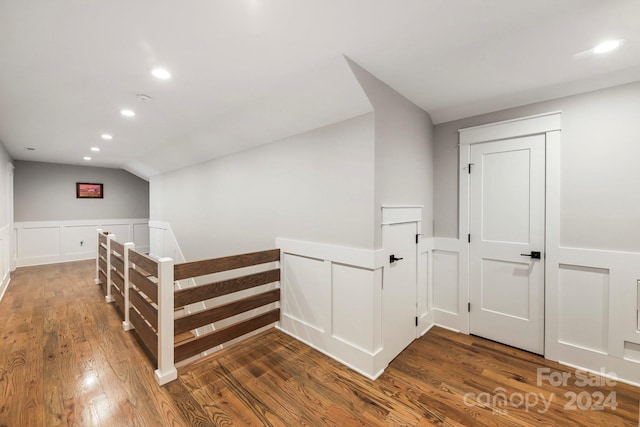 hall featuring vaulted ceiling and dark hardwood / wood-style flooring