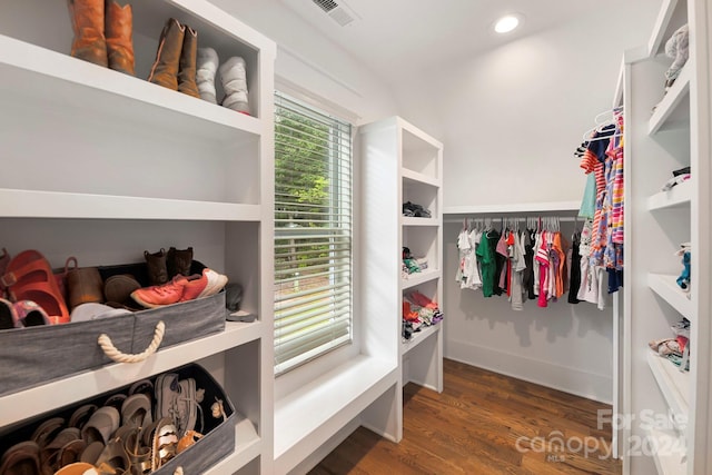 walk in closet with dark wood-type flooring