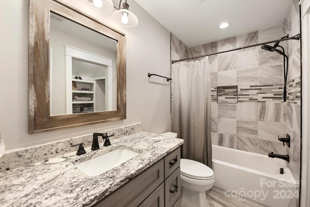 full bathroom featuring vanity, shower / bath combination with curtain, and toilet