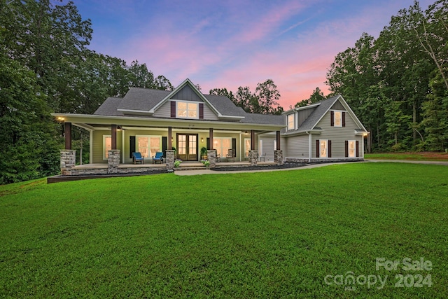 back house at dusk with a lawn