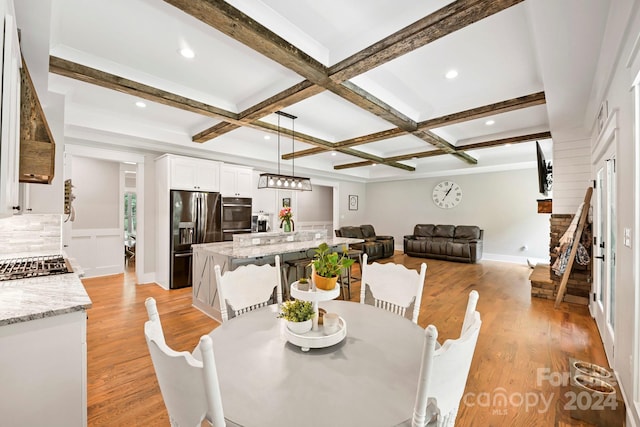 dining room featuring light hardwood / wood-style flooring, beam ceiling, and coffered ceiling