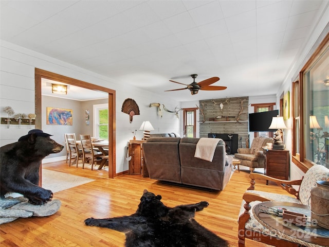 living room with a fireplace, wood finished floors, and a healthy amount of sunlight