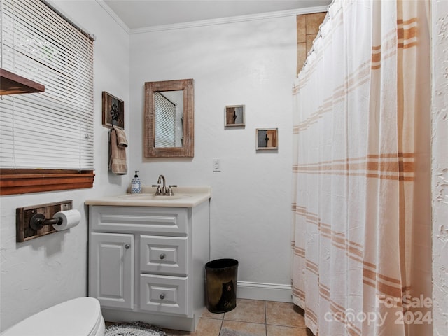 bathroom with baseboards, toilet, ornamental molding, tile patterned floors, and vanity