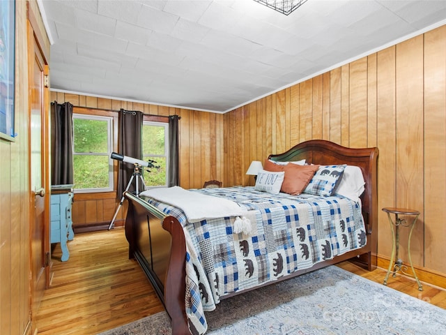 bedroom with wood walls and wood finished floors