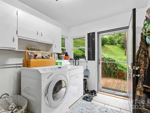 clothes washing area featuring cabinet space and washing machine and clothes dryer