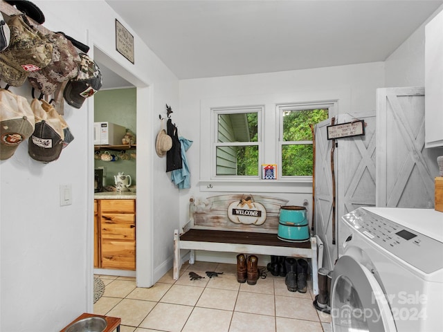 washroom with laundry area, light tile patterned floors, and washer and dryer