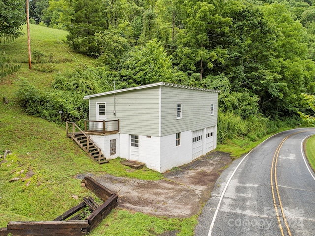 exterior space with a garage, stairway, and a wooden deck