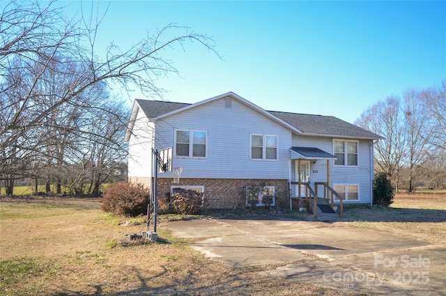 split foyer home with brick siding and a front yard