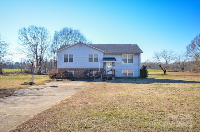 split foyer home featuring brick siding and a front lawn