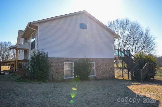 view of property exterior with brick siding and stairway